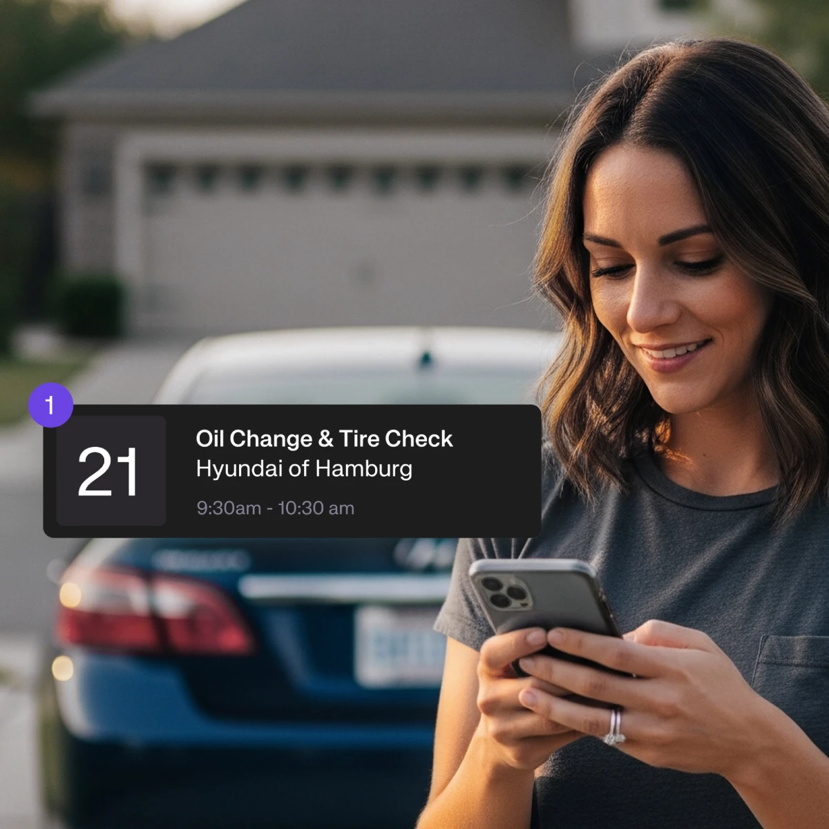 Woman checking a service appointment reminder notification on her phone for an oil change at Hyundai of Hamburg